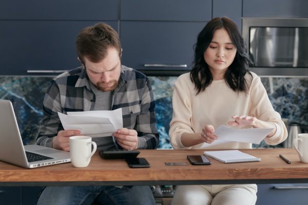 Un couple qui relit des factures et autres documents.