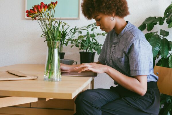 Femme assise à une table, utilisant sa tablette