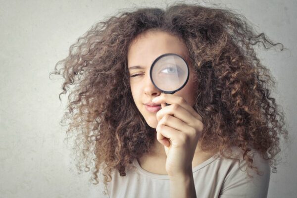 Une femme avec une loupe devant son oeil