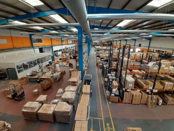 Grand entrepôt vu du dessus avec des cartons dans les allées et des palettes