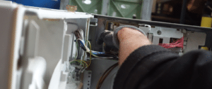 Un bras qui répare un système électronique de machine à laver