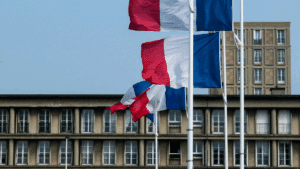Un bâtiment de collectivités avec des drapeaux français devant qui flottent au vent
