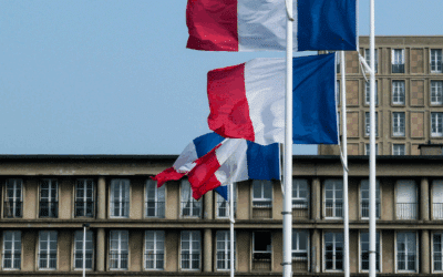 Un bâtiment de collectivités avec des drapeaux français devant qui flottent au vent