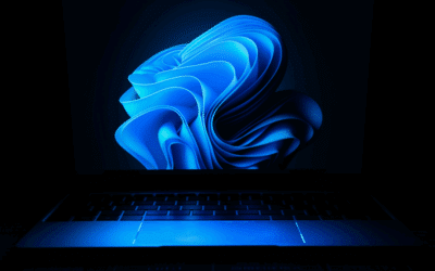 Visuel Windows très bleu, comme une fumée dans l'écran, éclairant le clavier d'ordinateur dans la pénombre.