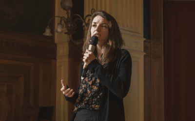 Laetitia Vasseur au micro dans une salle un peu sombre.