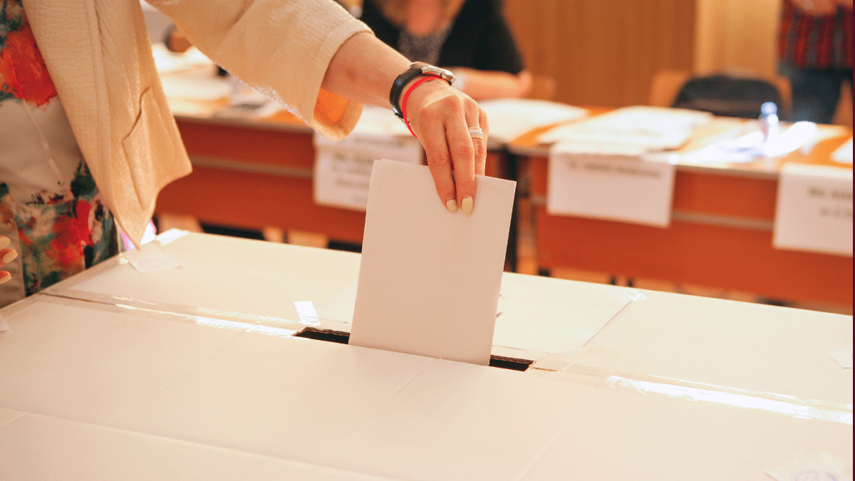 Une main manucurée met un bulletin dans l'urne