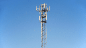 Antenne relais de téléphonie seule sur fond bleu.