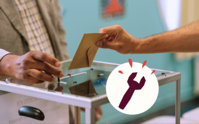 Une personne glisse son bulletin dans une urne transparente.