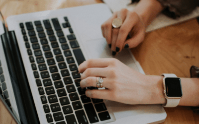 Un ordinateur portable vu de profil, avec les mains de l'utilisateur·ice posées sur le clavier